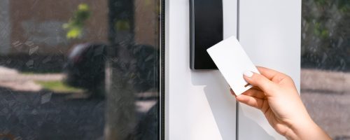 Woman using card to open door outdoors